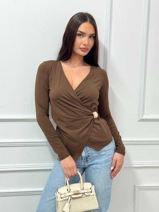 דוגמנית לובשת חולצת מעטפה עם אבזם מידה S